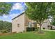 Side yard view of home with lush green grass and landscaping featuring a mature shade tree at 2755 Evan Manor Ln, Cumming, GA 30041