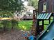 Lush backyard featuring a playhouse with a swing set, climbing wall, and a slide at 3641 Bramblewood Way, Marietta, GA 30062