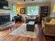 Cozy living room features a brick fireplace, large windows, hardwood flooring, and comfortable furnishings at 3641 Bramblewood Way, Marietta, GA 30062