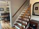 View of the wooden staircase with a dark wood railing leading to the second floor and view of dining room at 3641 Bramblewood Way, Marietta, GA 30062