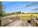 View of a wooden back deck overlooking a large grassy yard surrounded by trees at 4141 Willow Ridge Rd, Douglasville, GA 30135