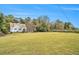 Wide-angle view showing back exterior, with a large grassy yard and surrounding trees at 4141 Willow Ridge Rd, Douglasville, GA 30135