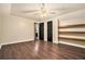 Spacious bedroom featuring hardwood floors, ceiling fan, access to the bathroom, and built-in shelving at 4141 Willow Ridge Rd, Douglasville, GA 30135