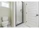Modern bathroom featuring a tiled shower with a glass enclosure, a toilet, and white marble flooring at 623 Hamilton E Holmes Nw Dr, Atlanta, GA 30318