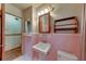 Pink bathroom showcasing a sink, toilet, and a small storage shelf at 629 Hickory Se Trl, Mableton, GA 30126