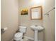 Well-lit powder room with pedestal sink, toilet, and decorative wall art at 1343 Penhurst Dr, Lawrenceville, GA 30043