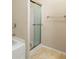 A well-lit bathroom showcasing a shower with glass door and neutral tile floors at 1343 Penhurst Dr, Lawrenceville, GA 30043