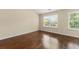 A bedroom showcasing gleaming hardwood floors and bright, natural light from two windows at 1343 Penhurst Dr, Lawrenceville, GA 30043