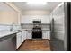 Modern kitchen showcasing stainless steel appliances, granite counters, and white cabinets at 1343 Penhurst Dr, Lawrenceville, GA 30043