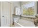 Relaxing bathroom features a soaking tub, decorative tile accents, and a window at 7275 Highland Blf # 8, Atlanta, GA 30328