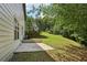 Large backyard featuring a concrete patio and a gently sloping, tree-lined lawn at 1025 Pebble Creek Trl, Suwanee, GA 30024