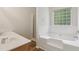 Bright bathroom with a dual sink vanity, soaking tub, and glass-enclosed shower at 1025 Pebble Creek Trl, Suwanee, GA 30024