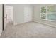 Spacious bedroom featuring neutral carpeting, large window, and a closet at 1025 Pebble Creek Trl, Suwanee, GA 30024