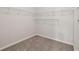 Walk-in closet featuring ample storage space with custom shelving and neutral carpeting at 1025 Pebble Creek Trl, Suwanee, GA 30024