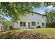 Exterior view of the back of the house with a concrete patio and large windows overlooking the backyard at 1025 Pebble Creek Trl, Suwanee, GA 30024
