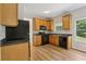 Bright kitchen featuring wood cabinets, black appliances, and a view of the backyard at 1025 Pebble Creek Trl, Suwanee, GA 30024