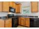 Cozy kitchen with wood cabinets, black appliances, and granite countertops at 1025 Pebble Creek Trl, Suwanee, GA 30024