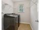Convenient laundry room features modern washer and dryer with functional wire shelving and natural light at 1025 Pebble Creek Trl, Suwanee, GA 30024