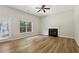 Open living room featuring a fireplace, natural light, and wood-look flooring at 1025 Pebble Creek Trl, Suwanee, GA 30024