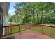 Wooden back deck overlooking a lush green backyard with mature trees and a privacy fence at 1181 Mannbrook Dr, Stone Mountain, GA 30083