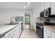 Modern kitchen with stainless steel appliances, and ample counter space with an opening to a light filled living space at 1181 Mannbrook Dr, Stone Mountain, GA 30083