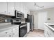 Well-equipped kitchen features stainless steel appliances, white cabinets, and stylish backsplash, ideal for modern living at 1181 Mannbrook Dr, Stone Mountain, GA 30083