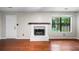 Bright living room featuring a white fireplace, dark wood mantel, and a window offering natural light at 1181 Mannbrook Dr, Stone Mountain, GA 30083