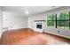 Spacious living room with a decorative fireplace, hardwood floors, and a large window offering ample natural light at 1181 Mannbrook Dr, Stone Mountain, GA 30083