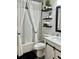 Bright bathroom features a shower with white curtain, toilet, sink and black floating shelves at 2706 Cedar Dr, Lawrenceville, GA 30043