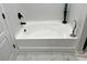 Clean white bathtub with black fixtures and stylish tile flooring at 2706 Cedar Dr, Lawrenceville, GA 30043