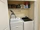 Functional laundry room with washer, dryer, and shelving for storage of laundry items at 2706 Cedar Dr, Lawrenceville, GA 30043