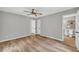 Bedroom featuring hardwood floors, ceiling fan, two doors, and doorway to a bathroom at 3100 Meadow Trl, Loganville, GA 30052