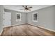 Bedroom featuring hardwood floors, ceiling fan, two windows, and a white painted door at 3100 Meadow Trl, Loganville, GA 30052