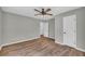 Bedroom with hardwood floors, ceiling fan, and doorway to a hallway in a home for sale at 3100 Meadow Trl, Loganville, GA 30052