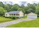 Charming one-story home with a inviting front porch, a lush lawn, and a detached two-car garage at 3100 Meadow Trl, Loganville, GA 30052