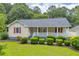 Charming single-story home with yellow siding, red shutters, and a welcoming front porch lined with green shrubs at 3100 Meadow Trl, Loganville, GA 30052