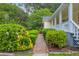 Manicured shrubbery lining the brick walkway leading to the inviting front porch on this charming home at 3100 Meadow Trl, Loganville, GA 30052