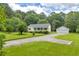 Charming one-story home with a lush green lawn, mature trees, and a detached two-car garage at 3100 Meadow Trl, Loganville, GA 30052