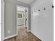 Hallway with wood-look floors, board and batten wall with hooks, and doorways to other rooms at 3100 Meadow Trl, Loganville, GA 30052