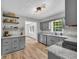 Modern kitchen with gray cabinets, granite countertops, stainless appliances, and open shelving for a clean, contemporary feel at 3100 Meadow Trl, Loganville, GA 30052