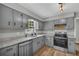Updated kitchen with stainless steel appliances, granite countertops, gray cabinets, and new flooring for a modern look at 3100 Meadow Trl, Loganville, GA 30052