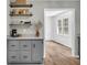 Charming kitchen featuring gray cabinets with granite countertops, open shelving, and natural lighting, creating a functional and stylish space at 3100 Meadow Trl, Loganville, GA 30052