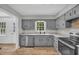 Well-lit kitchen featuring granite countertops, stainless steel appliances, gray cabinetry, and an eat-in dining area at 3100 Meadow Trl, Loganville, GA 30052
