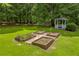 Expansive yard featuring a gazebo and raised garden beds surrounded by lush greenery and mature trees at 3100 Meadow Trl, Loganville, GA 30052