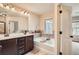 Well-lit bathroom with double vanity and a soaking tub with tile surround at 3280 Hallmark Ln, Buford, GA 30519