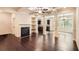 Open-concept living room with fireplace, built-in shelving, and hardwood floors at 3280 Hallmark Ln, Buford, GA 30519