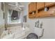Bathroom features a large tub with jets, oak cabinets, and decoratively framed mirror at 5609 Twin Oak Dr, Douglasville, GA 30135
