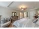 Bedroom with bed, dresser, couch near the door to the bathroom, and tray ceiling with ceiling fan at 5609 Twin Oak Dr, Douglasville, GA 30135