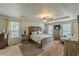 Bedroom suite featuring neutral walls, tray ceiling, ceiling fan, a large bed and a dresser near two windows at 5609 Twin Oak Dr, Douglasville, GA 30135
