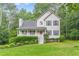 Charming two-story home with grey siding, shutters, a cozy front porch, and lush landscaping at 5609 Twin Oak Dr, Douglasville, GA 30135